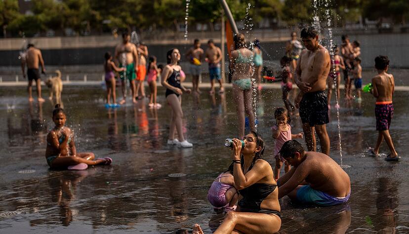 Menschen in Madrid erfrischen sich mit kühlendem Wasser. Menschen in Madrid erfrischen sich mit kühlendem Wasser.