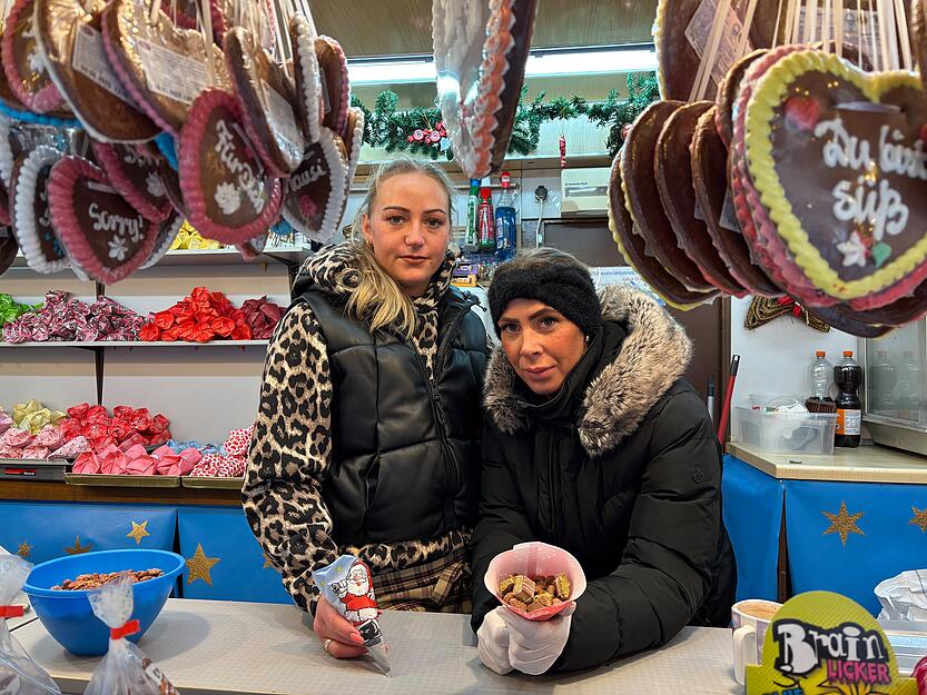 Schwiegertochter Jessica hält eine Packung Mandeln mit Dubai-Schokolade in die Kamera. Daneben steht Charmaine, die Enkelin der Inhaberin.