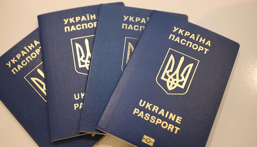 Vier Reisepässe von Geflüchteten aus der Ukraine liegen auf einem Tisch.