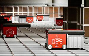 Die kleinen Roboter holen eine Kiste nach der anderen aus dem Lager unter ihnen. Dann werden die Produkte zu den Mitarbeitern gebracht, die Pakete für den Versand fertig machen. Die kleinen Roboter holen eine Kiste nach der anderen aus dem Lager unter ihnen. Dann werden die Produkte zu den Mitarbeitern gebracht, die Pakete für den Versand fertig machen.