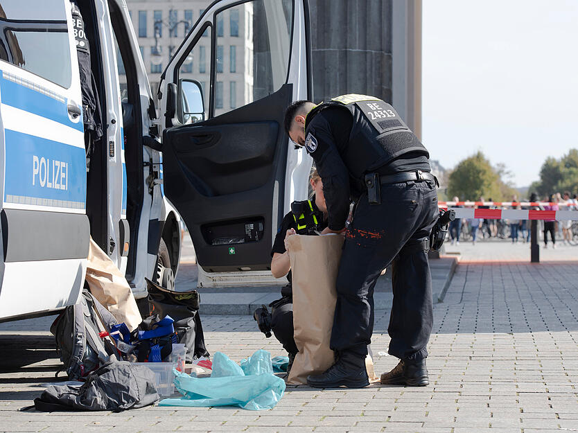 Polizeibeamte sichern am Brandenburger Tor Beweisst&uuml;cke.