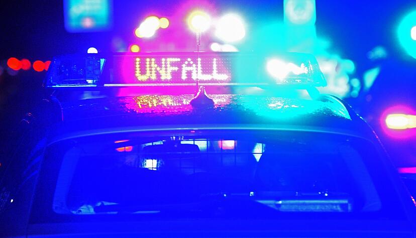 Ein Streifenwagen der Polizei steht mit Blaulicht an einer Unfallstelle.