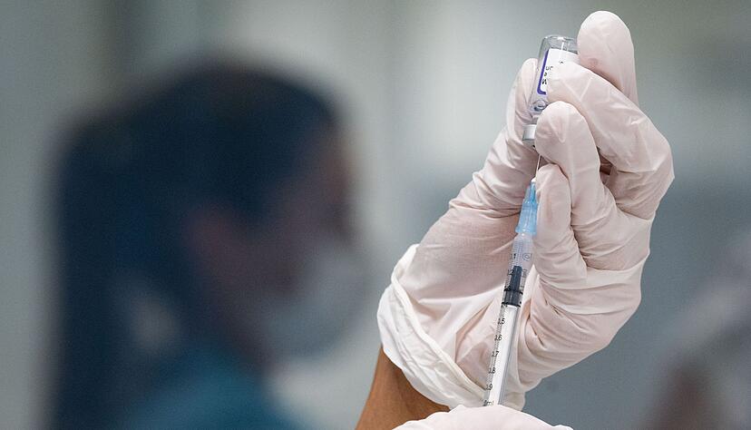 Eine Frau zieht eine Dosis des Impfstoffes von Biontech/Pfizer f&uuml;r eine Corona-Impfung auf.