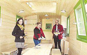 Laura Wedekind (links), Jasmin Weinmann und B&uuml;rgermeister Timo Wolf zeigen, wie die Unterkunft im Inneren ausgestattet ist.