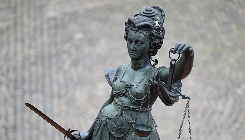 Eine Statue der Justitia h&auml;lt eine Waage und ein Schwert in der Hand.