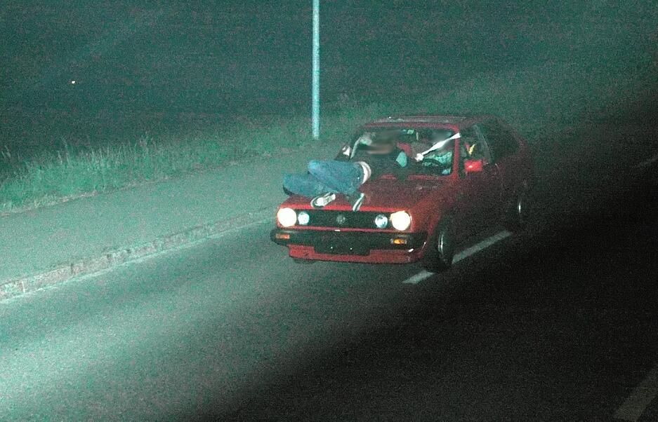 Waghalsige Aktion: Ein Mann und eine Frau (auf der Kühlerhaube) rasen absichtlich mit 86 Kilometern pro Stunde in eine Radarfalle, um ein „perfektes Bild“ zu inszenieren. Obwohl sie die Nummernschilder vorher abmontierten, wurden sie identifiziert und erhielten saftige Strafen. Waghalsige Aktion: Ein Mann und eine Frau (auf der Kühlerhaube) rasen absichtlich mit 86 Kilometern pro Stunde in eine Radarfalle, um ein „perfektes Bild“ zu inszenieren. Obwohl sie die Nummernschilder vorher abmontierten, wurden sie identifiziert und erhielten saftige Strafen.