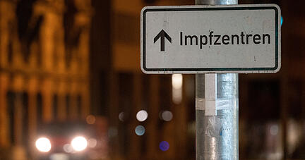 Ein Schild weist in der Stuttgarter Innenstadt den Weg zu Impfzentren.