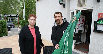 Wollen auf ihrer Terrasse im Jack"s Angel Pub nicht 30 Stunden weniger Öffnungszeit gegenüber der Innenstadt akzeptieren: Andrea und Thomas Engel.
Foto: Carsten Friese