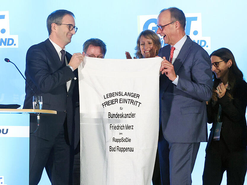 Erinnerung an den Kraichgau: Bad Rappenaus OB Sebastian Frei &uuml;berreicht Friedrich Merz ein Rappsodie-Handtuch.