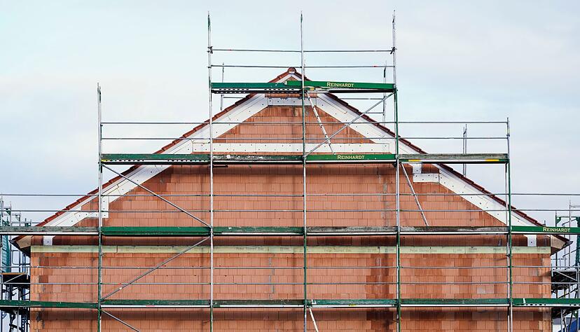 Ein Gerüst steht in einem Neubaugebiet an einem Rohbau. Die Baubranche erlebt einen regelrechten Auftragseinbruch. Ein Gerüst steht in einem Neubaugebiet an einem Rohbau. Die Baubranche erlebt einen regelrechten Auftragseinbruch.