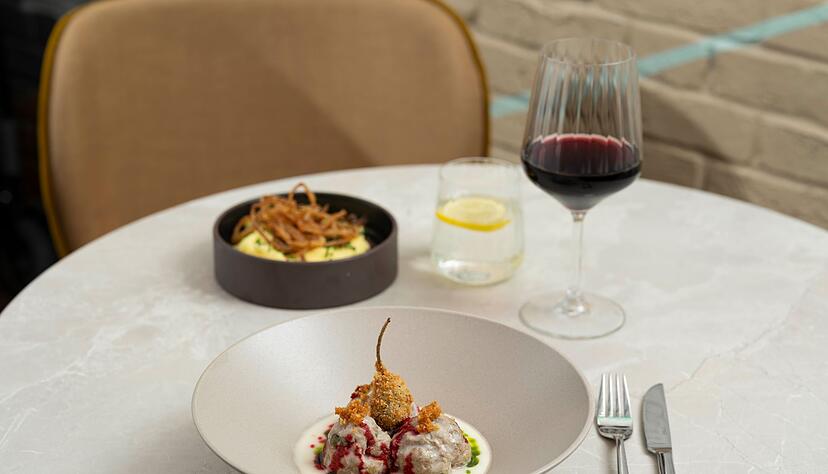 Der frittierte Kapernapfel und die Tr&ouml;pfchen von dem eingekochten Rote-Bete-Sirup geben den K&ouml;nigsberger Klopsen zus&auml;tzlich Textur sowie Crunch und sorgen f&uuml;r ein Spiel mit S&auml;ure-Nuancen.