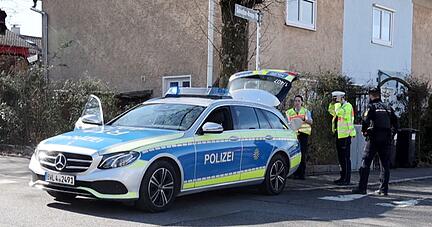 Einsatzkräfte der Polizei stehen an Einsatzfahrzeugen.