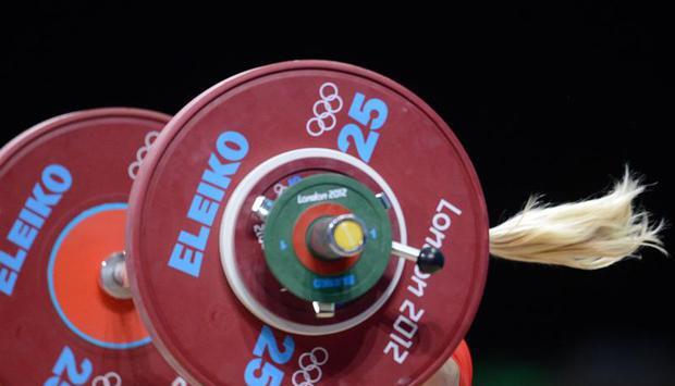 Mit viel Schwung reißt die deutsche Ausnahmeathletin die Hantel über den Kopf. Foto: Bernd Thissen Mit viel Schwung reißt die deutsche Ausnahmeathletin die Hantel über den Kopf. Foto: Bernd Thissen