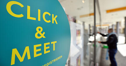 "Click & Meet" steht am Schaufenster eines Warenhauses, während die Scheiben geputzt werden. In Thüringen gibt es angesichts sinkender Infektionszahlen weitere Lockerungen. In der Thüringer Landeshauptstadt Erfurt ist ab 17. Mai ein Einkaufsbummel nach vorheriger Terminbuchung möglich. +++ dpa-Bildfunk +++