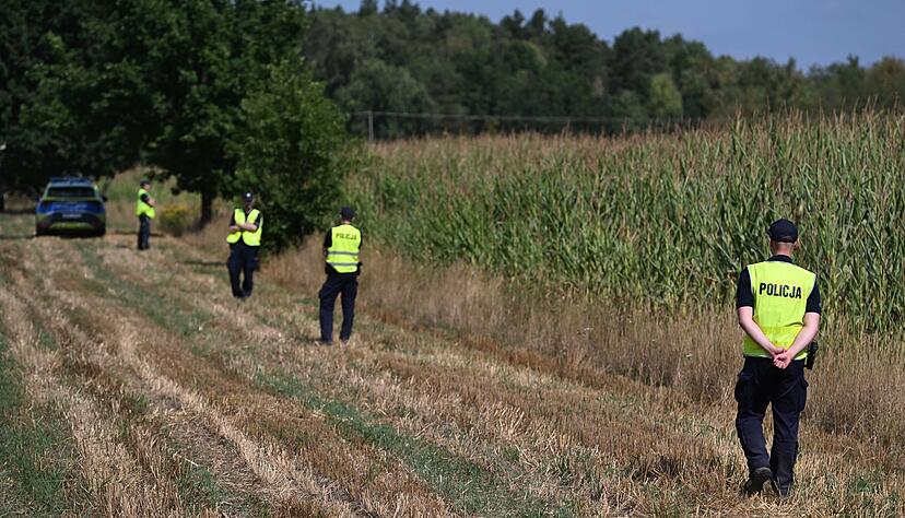 Polnische Polizisten sichern das Gebiet eines Maisfeldes in Osiny in Ostpolen, in das ein unbekanntes Flugobjekt gest&uuml;rzt ist. (Foto aktuell)
