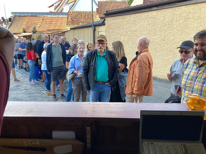 Eine lange Schlange bildet sich vor dem Unteren Backhaus. Der Duft von Zwiebelkuchen lockt dutzende Besucher des Erlenbacher Weinfestes an.