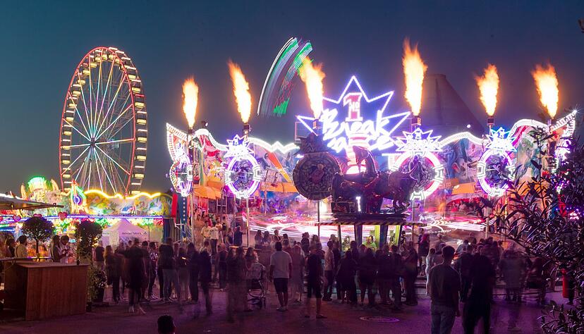 Leuchtende Fahrgeschäfte auf dem Heilbronner Volksfest.