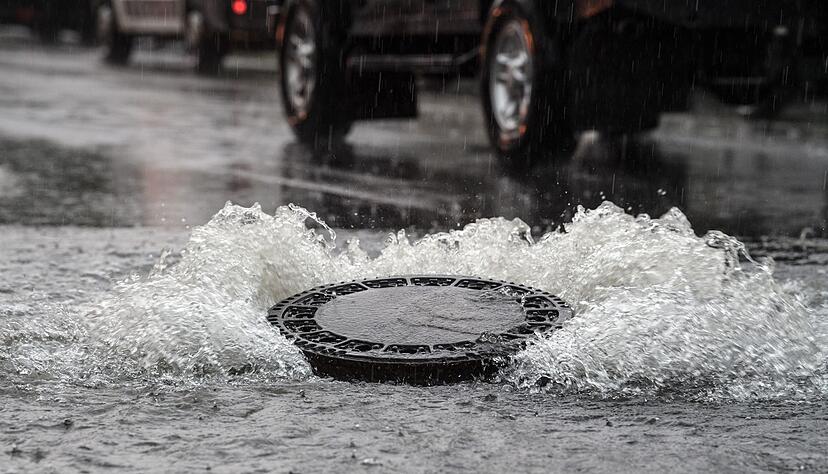 Im Landkreis Aschaffenburg hoben die Wassermassen einige Gullydeckel aus. (Symbolbild)