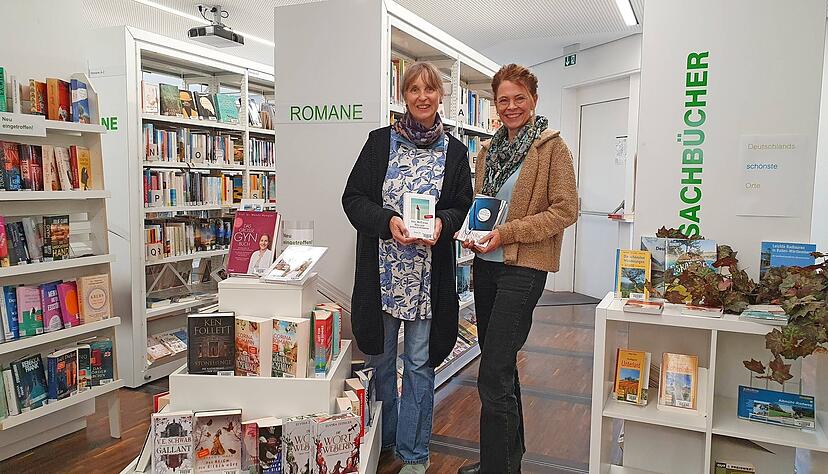 Eva Lürkens (rechts) und Jutta Schultz mit Buchempfehlungen, darunter „Das schwarze Manifest“ von Heinrich Steinfest – bald zu Gast in der Medienwelt.
Foto: Möllers