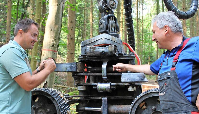 Maschinenf&uuml;hrer Klaus Ruoff (rechts) erkl&auml;rt Revierleiter Alexander Fichtner das Aggregat mit Messern, Antriebswalzen, Kapps&auml;ge und den Messinstrumenten.