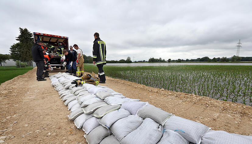 Feuerwehrleute und freiwillige Helfer befestigen nach einem Dammbruch einen zweiten Damm mit Sandsäcken, um das Hochwasser zu stoppen. Feuerwehrleute und freiwillige Helfer befestigen nach einem Dammbruch einen zweiten Damm mit Sandsäcken, um das Hochwasser zu stoppen.