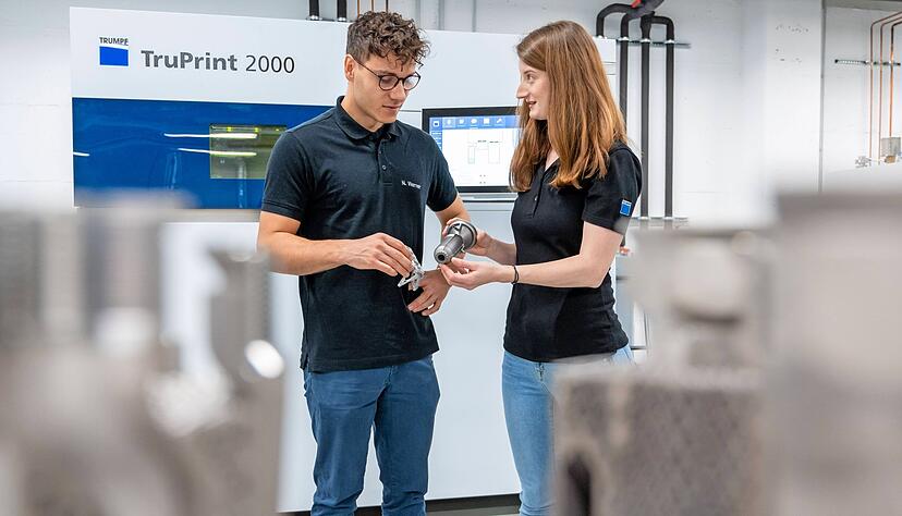 Zwei Trumpf-Mitarbeiter mit der Schubdüse aus dem 3D-Drucker. Das Bauteil kommt bei einer der nächsten Mond-Missionen zum Einsatz