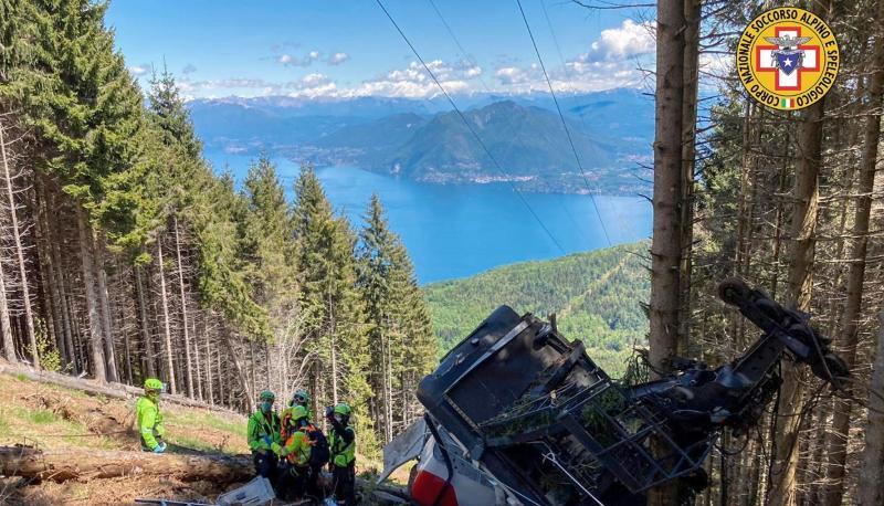 Rettungskr&auml;fte stehen am Wrack der Gondel, die in der N&auml;he des Gipfels abgest&uuml;rzt ist. Foto: dpa
