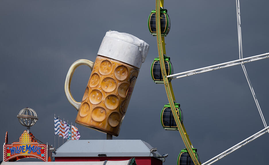 Ein überdimensionaler Bierkrug ist vor einem Riesenrad zu sehen. Ein überdimensionaler Bierkrug ist vor einem Riesenrad zu sehen.