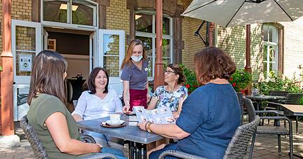 Unter Bäumen und Sonnenschirmen trinken auch die Mitarbeiter gerne einen Café oder Cappuccino: Claudia Kellermann (vorne, von rechts), Birgit Karl, Sabine Vikar und Kira Stammer.
Fotos: Christiana Kunz Unter Bäumen und Sonnenschirmen trinken auch die Mitarbeiter gerne einen Café oder Cappuccino: Claudia Kellermann (vorne, von rechts), Birgit Karl, Sabine Vikar und Kira Stammer.
Fotos: Christiana Kunz