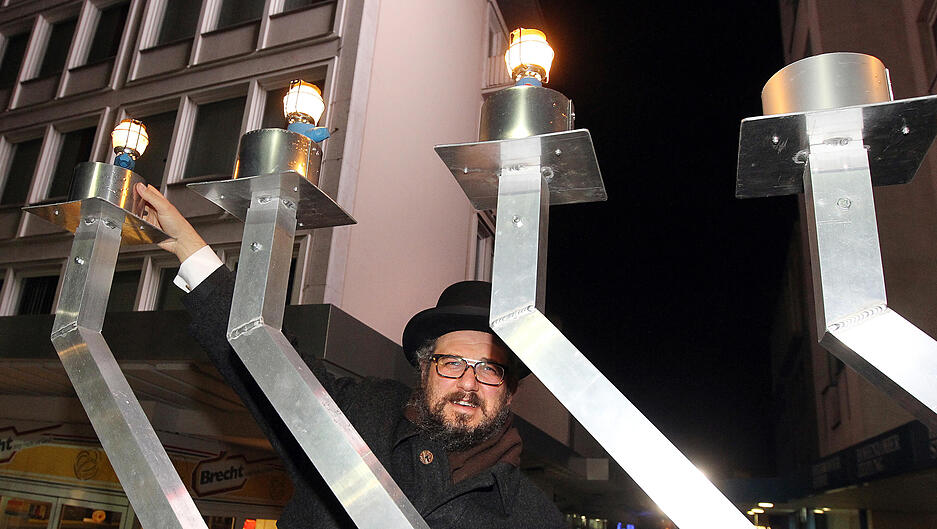 Am großen Leuchter in der Heilbronner Synagogengasse wird 2015 das dritte Licht angezündet. Bis die achte Kerze brennt feiert die jüdische Gemeinde das Lichterfest Chanukka.
