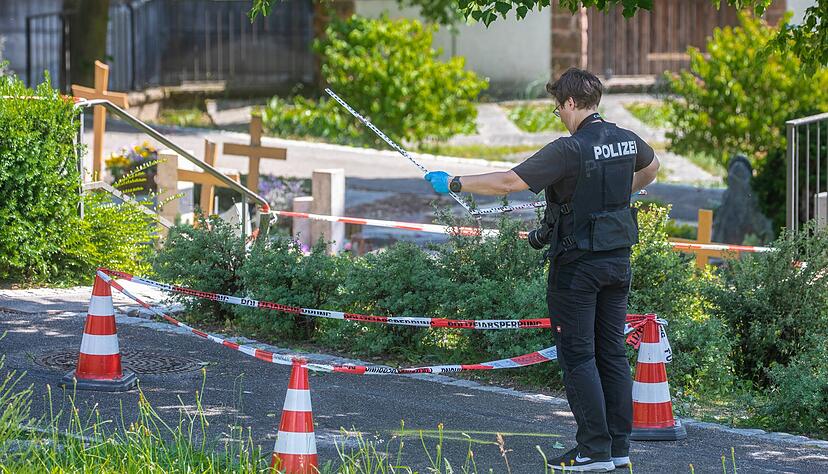 Eine Mitarbeiterin der Spurensicherung vermisst Spuren an einem Tatort auf einem Friedhof. Durch den Wurf eines explodierenden Gegenstands auf eine Trauergemeinde gab es mehrere Verletzte.