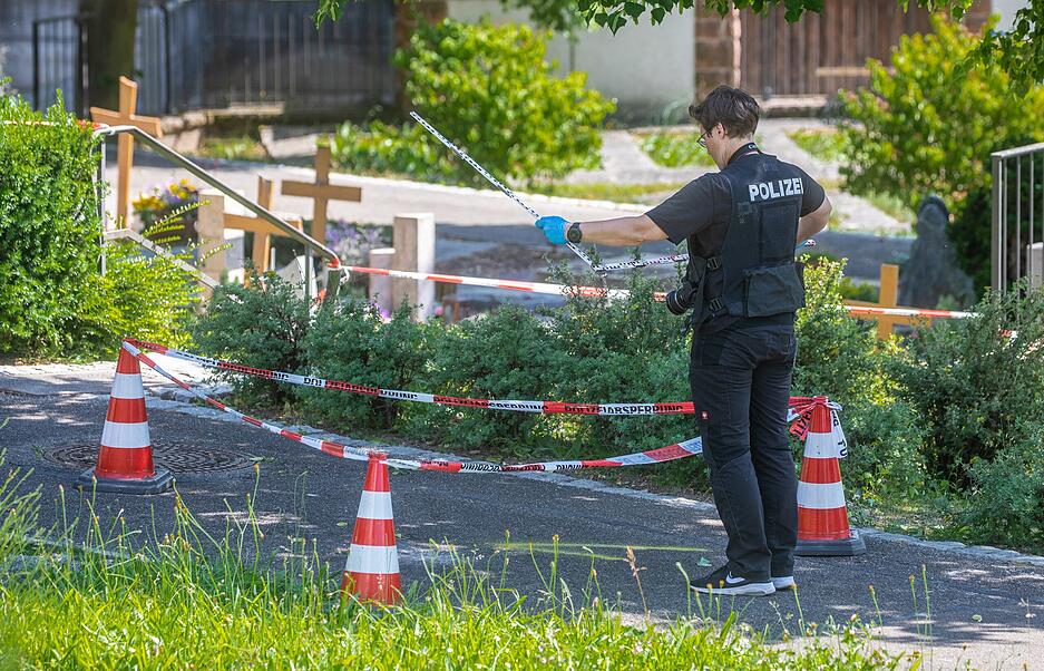Eine Mitarbeiterin der Spurensicherung vermisst Spuren an einem Tatort auf einem Friedhof. Durch den Wurf eines explodierenden Gegenstands auf eine Trauergemeinde gab es mehrere Verletzte. Eine Mitarbeiterin der Spurensicherung vermisst Spuren an einem Tatort auf einem Friedhof. Durch den Wurf eines explodierenden Gegenstands auf eine Trauergemeinde gab es mehrere Verletzte.