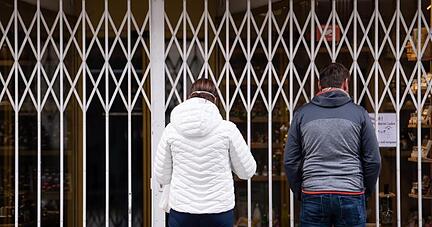 Zwei Passanten stehen in einer Fu&szlig;g&auml;ngerzone vor einem geschlossenen Gesch&auml;ft.