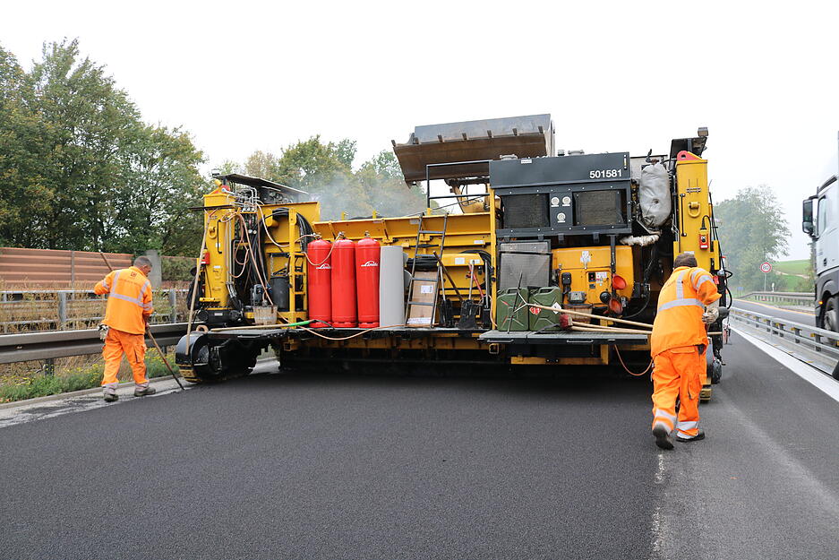 Langsam f&auml;hrt das Asphaltierfahrzeug auf der A6. Die Flamme erhitzt den Bohlenschuh unter dem Fahrzeug.