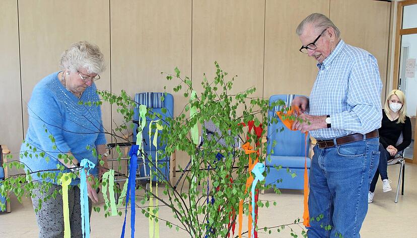 Hermine M&uuml;nch und Gerhard Werner sind G&auml;ste in der DRK-Tagespflege. Sie schm&uuml;cken Birkenzweige mit bunten B&auml;ndern. Das weckt Erinnerungen an fr&uuml;her.