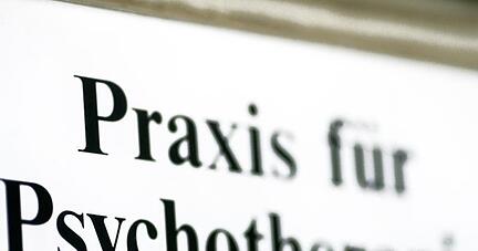 Ein Schild weist auf eine Praxis für Psychotherapie hin.