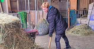 Christina Jäger beim Heu verteilen. Zwei Großballen pro Tag braucht sie für die Pferde.