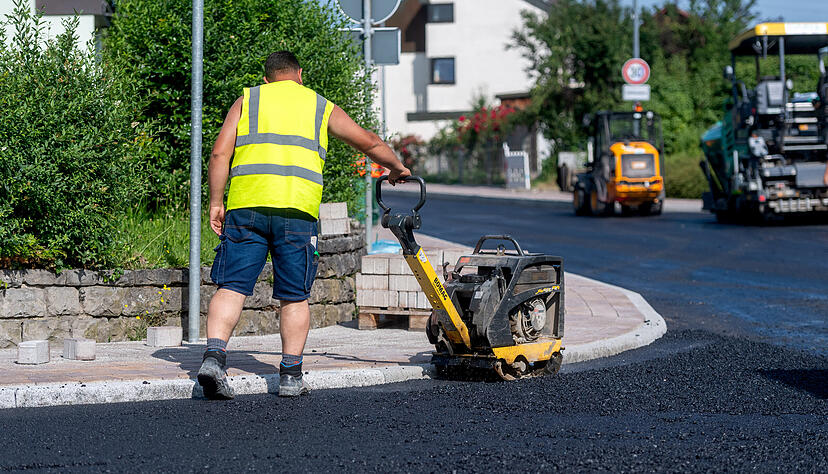 An den Randsteinkanten kann die Walze den Asphalt nicht verfestigen. Da kommen kleinere Baumaschinen zum Einsatz.