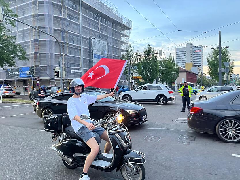 Auch ein Roller-Fahrer ist bei dem Auto-Korso dabei.