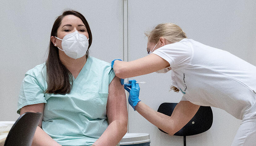 Christine Helbig (l), Pflegekraft am Klinikum Stuttgart, ist eine der ersten Menschen in Baden-Württemberg, die geimpft wurden. Am Sonntag haben die Corona-Impfungen mit dem Impfstoff von Biontech/Pfizer in Deutschland begonnen.