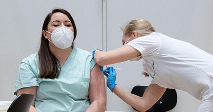 Christine Helbig (l), Pflegekraft am Klinikum Stuttgart, ist eine der ersten Menschen in Baden-Württemberg, die geimpft wurden. Am Sonntag haben die Corona-Impfungen mit dem Impfstoff von Biontech/Pfizer in Deutschland begonnen.