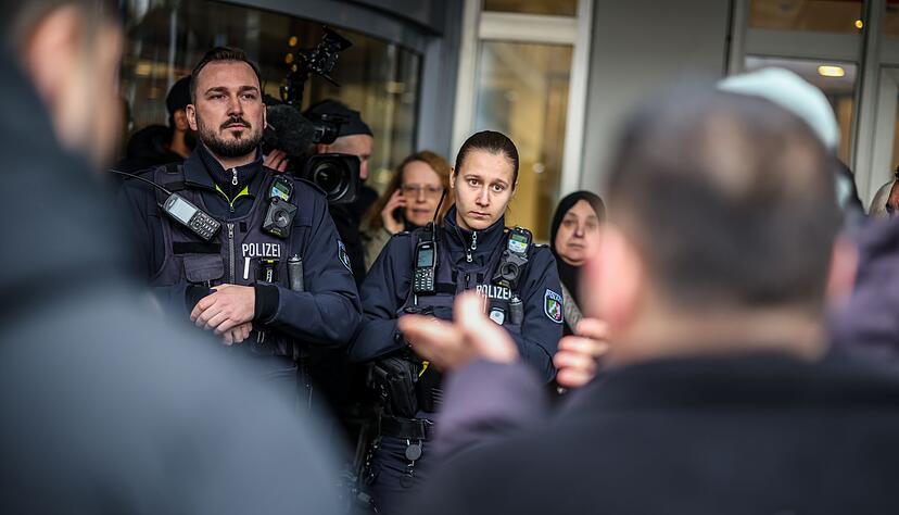 Polizeibeamte sprechen mit m&ouml;glicherweise betroffenen Kunden der Sparkassenfiliale in Buer.