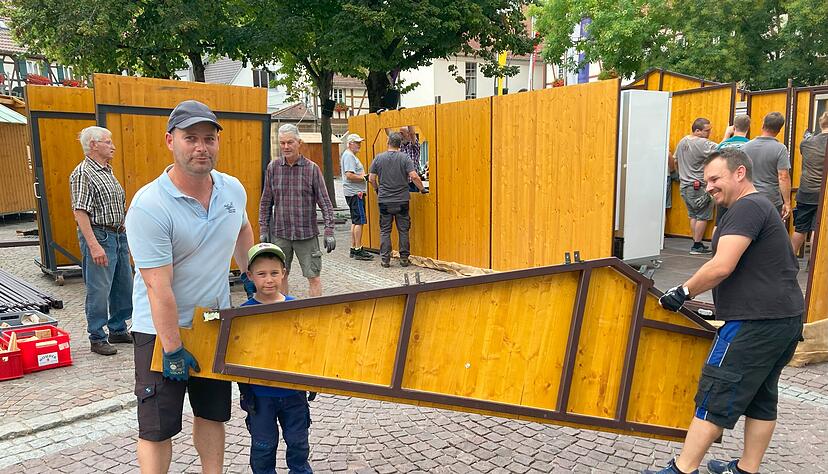 Alle Generationen packen mit an: ehrenamtliche Helfer bauen den Stand der Freiwilligen Feuerwehr auf.