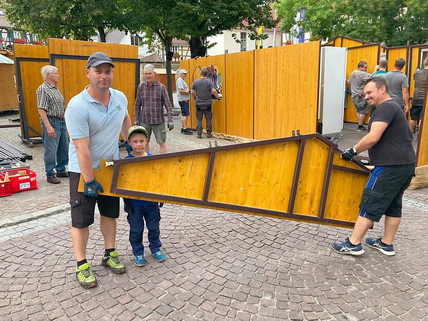 Alle Generationen packen mit an: ehrenamtliche Helfer bauen den Stand der Freiwilligen Feuerwehr auf.