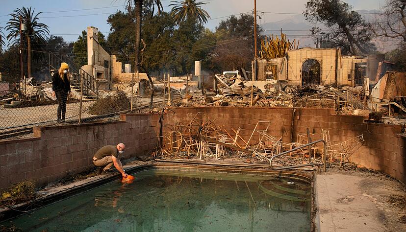 Robert Karban f&uuml;llt einen Eimer mit Wasser aus einem Swimmingpool.
