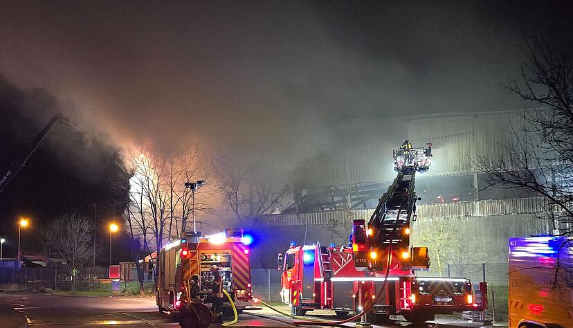 Feuerwehrleute l&ouml;schen den Brand in einem Entsorgungsbetrieb.