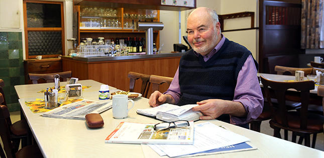 Lothar Hesser mit Notizbuch in seiner Gaststätte. Foto: Veigel
