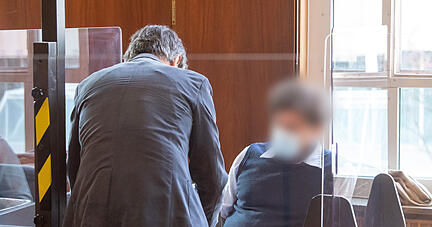 Der Angeklagte spricht während des Prozessauftakts vor dem Landgericht Stuttgart nach einem Überfall auf einen Altgoldtransporter im Jahr 2009 mit seinem Verteidiger. Gemeinsam mit sechs Komplizen soll er einen Altgoldtransport ausgeraubt haben - getarnt als Steuerfahnder und Polizisten.  Foto: dpa Der Angeklagte spricht während des Prozessauftakts vor dem Landgericht Stuttgart nach einem Überfall auf einen Altgoldtransporter im Jahr 2009 mit seinem Verteidiger. Gemeinsam mit sechs Komplizen soll er einen Altgoldtransport ausgeraubt haben - getarnt als Steuerfahnder und Polizisten.  Foto: dpa