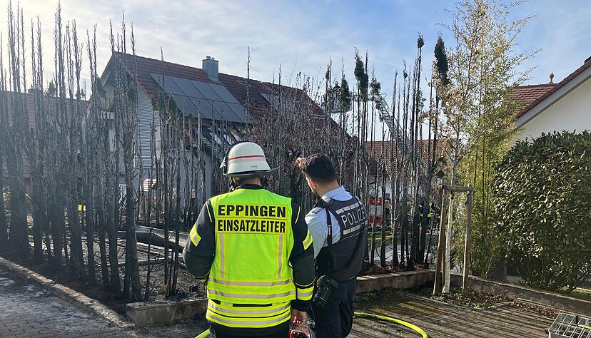 Die Feuerwehr ist mit einer Drehleiter im Einsatz und deckt eine Solaranlage auf einem Hausdach ab.