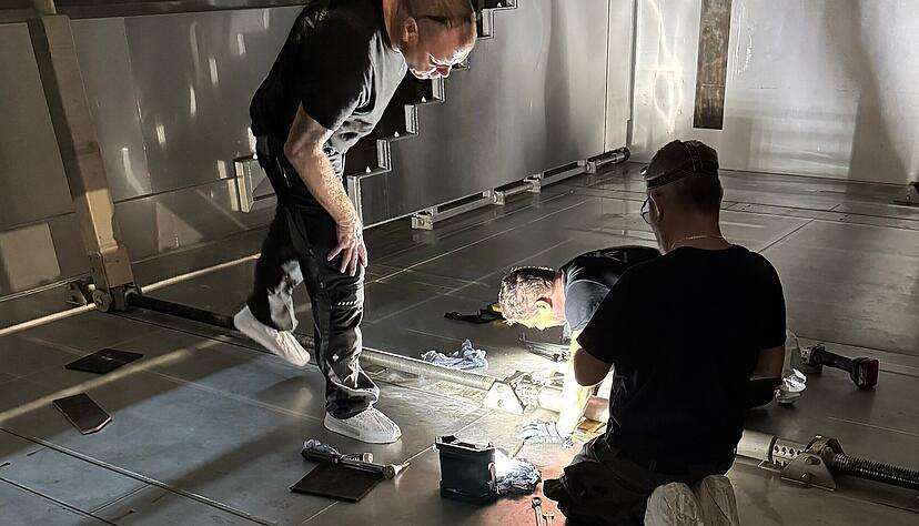 Unter dem hochgefahrenen Boden des Beckens tauschen die Handwerker ein defektes Teil aus. Unter dem hochgefahrenen Boden des Beckens tauschen die Handwerker ein defektes Teil aus.